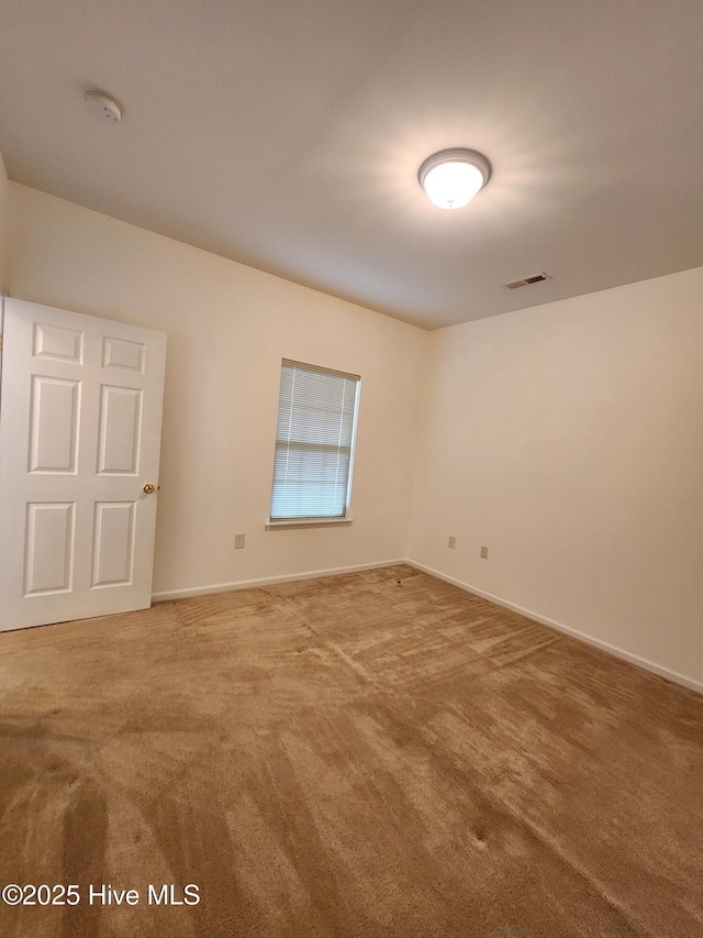 carpeted empty room with baseboards and visible vents