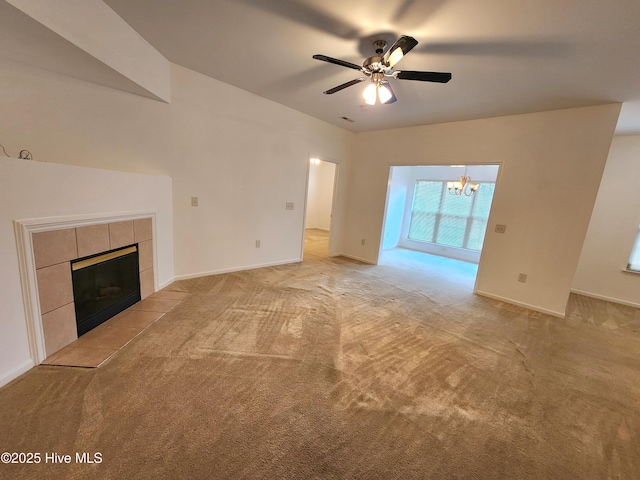 unfurnished living room featuring light carpet, ceiling fan with notable chandelier, and a fireplace