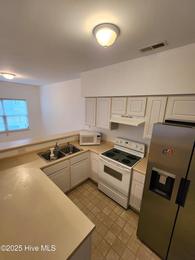 kitchen with under cabinet range hood, white appliances, a sink, visible vents, and light countertops