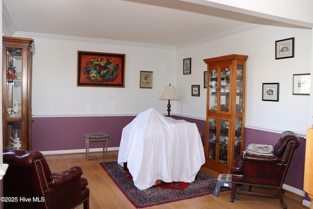 interior space with ornamental molding, baseboards, and wood finished floors