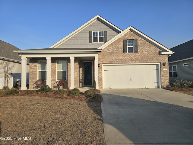 craftsman-style home with covered porch, concrete driveway, and brick siding