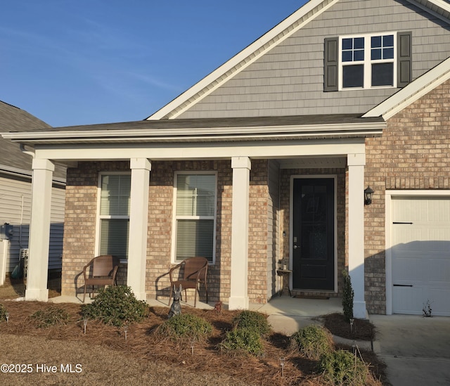 entrance to property with covered porch and brick siding