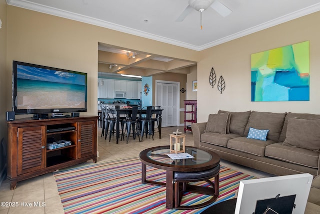 living area with ceiling fan, ornamental molding, light tile patterned flooring, and coffered ceiling