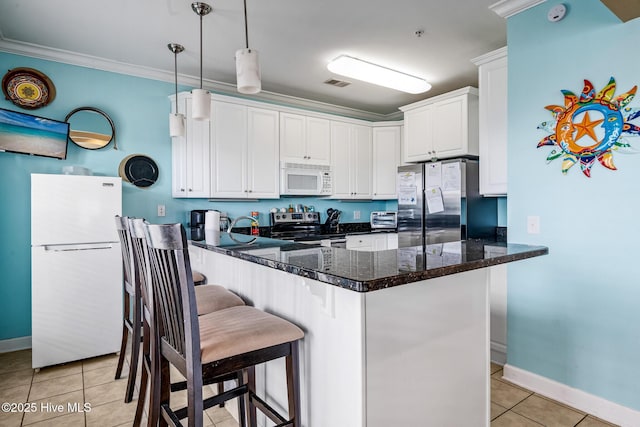 kitchen featuring light tile patterned floors, stainless steel appliances, ornamental molding, white cabinets, and a peninsula