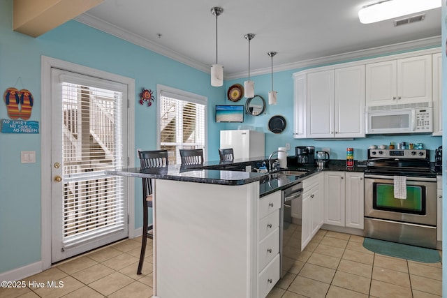 kitchen with light tile patterned flooring, a peninsula, visible vents, ornamental molding, and appliances with stainless steel finishes