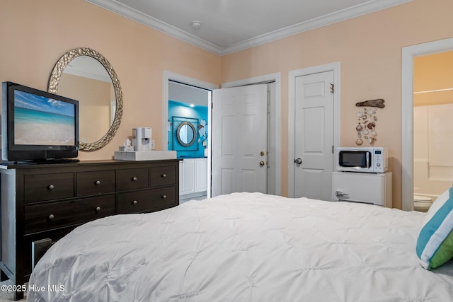 bedroom featuring ornamental molding, multiple closets, and ensuite bathroom