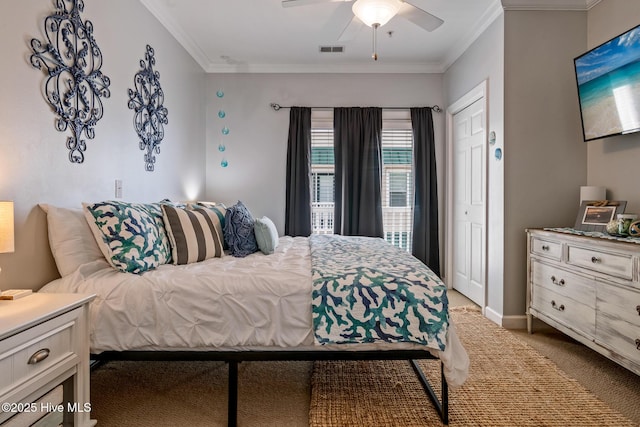 carpeted bedroom featuring baseboards, visible vents, ceiling fan, ornamental molding, and a closet