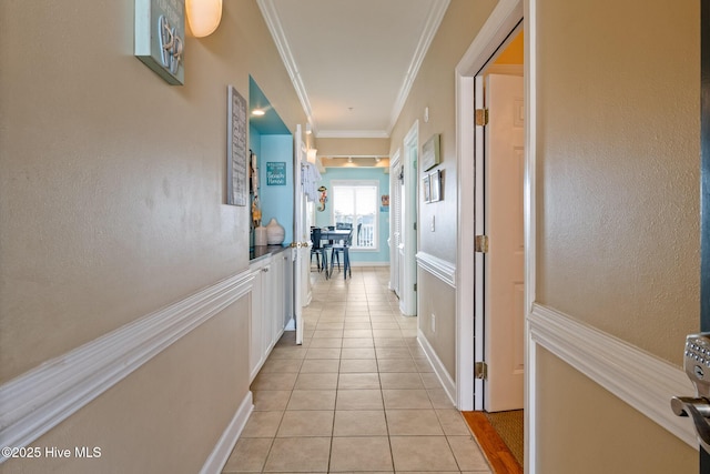 hallway featuring light tile patterned flooring and crown molding