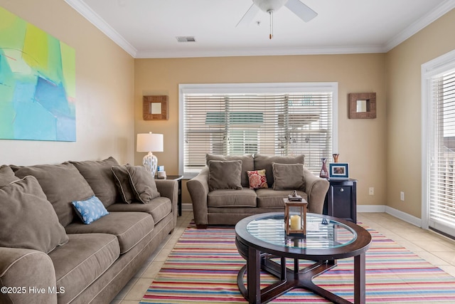 living area featuring light tile patterned floors, baseboards, visible vents, a ceiling fan, and ornamental molding