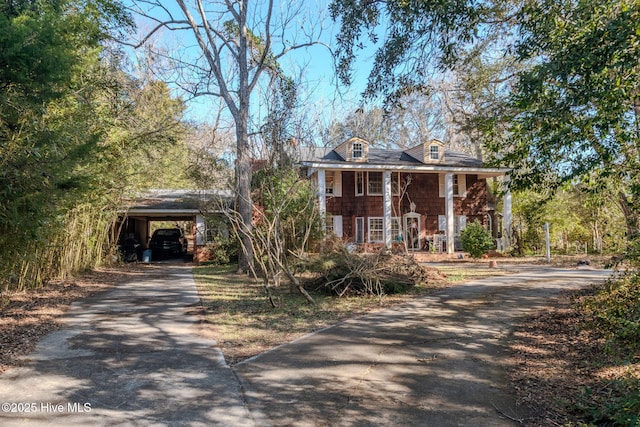 greek revival inspired property featuring a porch and concrete driveway