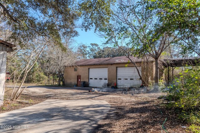 122 Old Fayetteville Rd, Leland, NC 28451 - view of side of property with stucco siding, driveway, and an outdoor structure