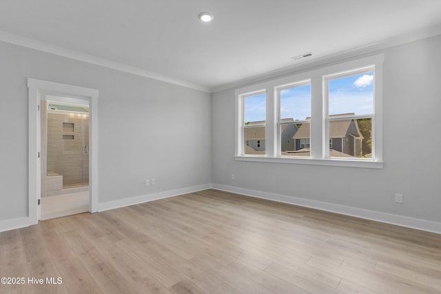 interior space featuring light wood finished floors, baseboards, and crown molding