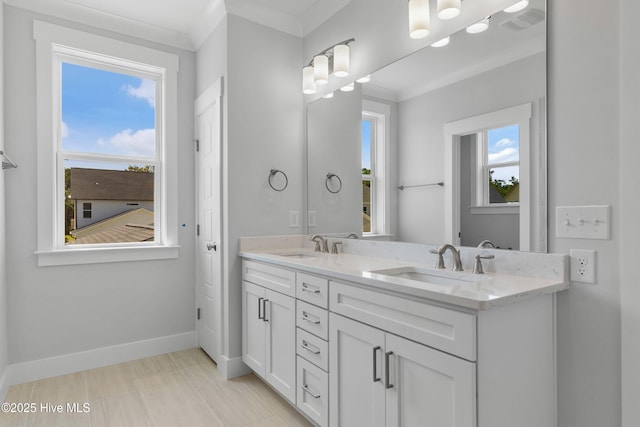 full bath with a healthy amount of sunlight, a sink, baseboards, and double vanity