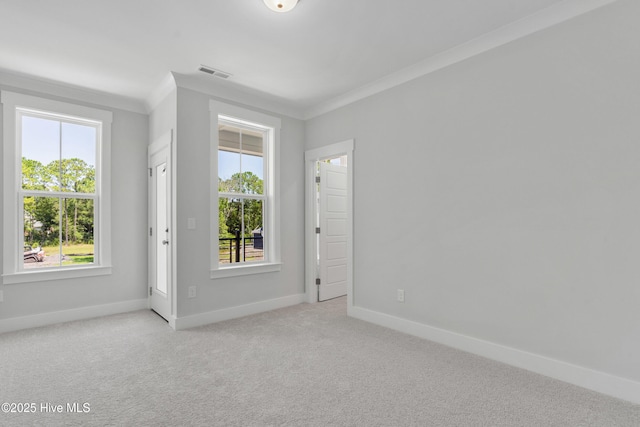 empty room featuring carpet floors, ornamental molding, visible vents, and baseboards