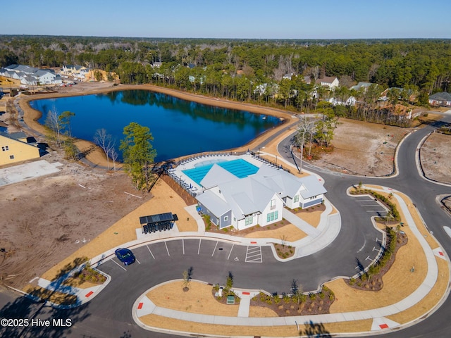 drone / aerial view featuring a water view and a wooded view