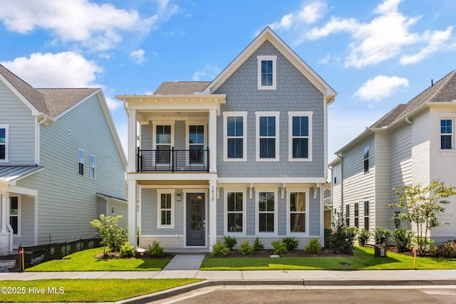 view of front of property with a front yard and a balcony