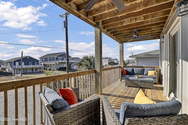 wooden terrace with ceiling fan, a residential view, and outdoor lounge area