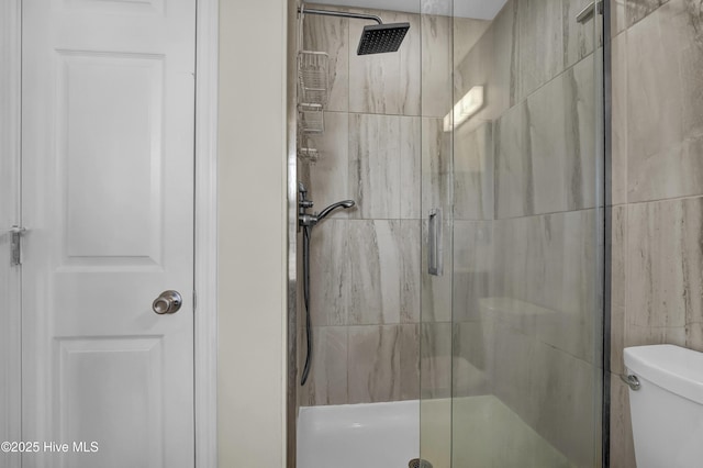 bathroom with a shower stall and toilet