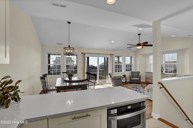 kitchen with vaulted ceiling, a wealth of natural light, oven, and visible vents