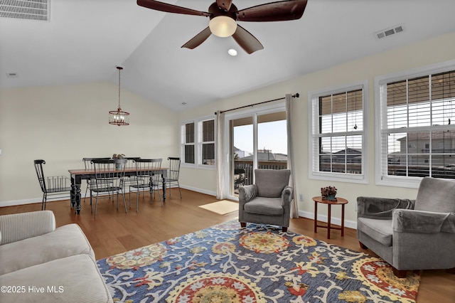 living area with vaulted ceiling, wood finished floors, and visible vents