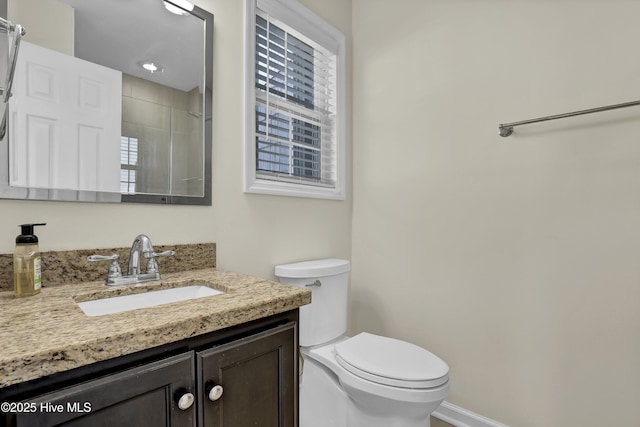 bathroom featuring toilet, baseboards, a tile shower, and vanity