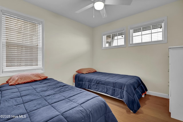 bedroom with wood finished floors, a ceiling fan, and baseboards