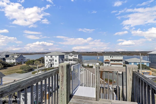 wooden deck with a residential view and a water view