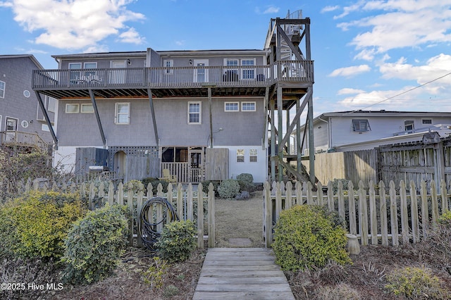 rear view of house featuring fence