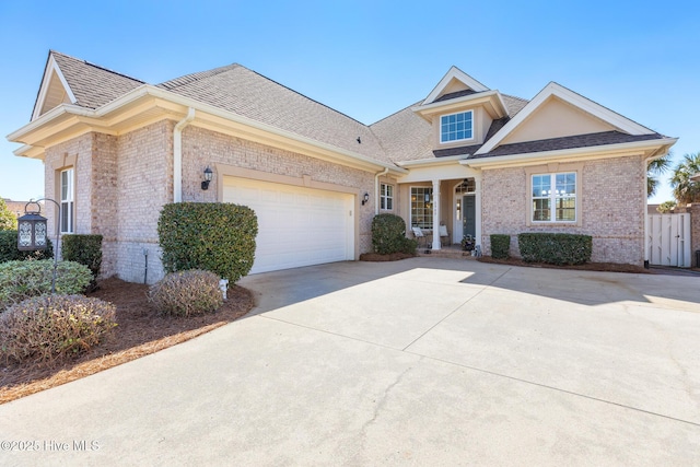 view of front of property with a garage, concrete driveway, brick siding, and roof with shingles