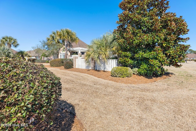 view of side of property featuring fence, a gate, and a pergola