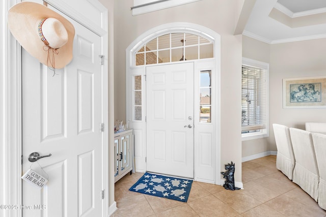 foyer with baseboards, light tile patterned flooring, and crown molding