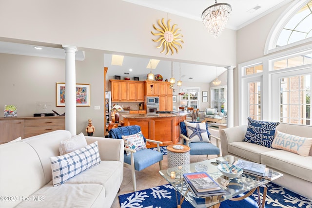 living area featuring light tile patterned flooring, crown molding, a towering ceiling, decorative columns, and an inviting chandelier