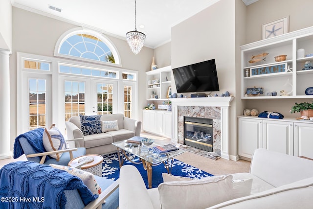 living room featuring a high end fireplace, visible vents, ornamental molding, french doors, and light tile patterned flooring