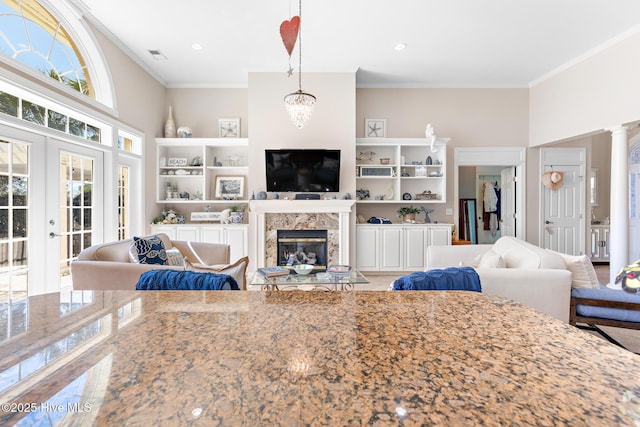 living room featuring recessed lighting, a fireplace, visible vents, french doors, and ornamental molding