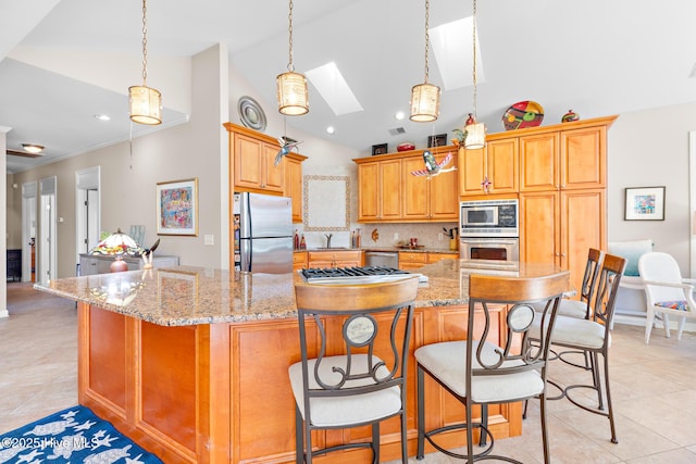 kitchen with a breakfast bar area, appliances with stainless steel finishes, light stone counters, a sink, and light tile patterned flooring