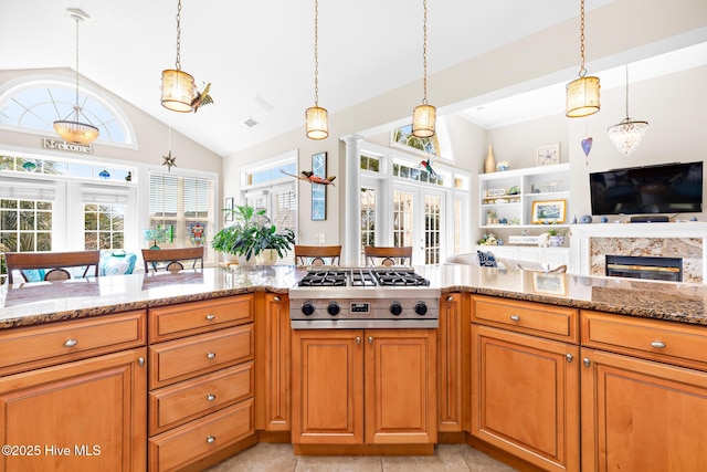 kitchen with stainless steel gas cooktop, french doors, open floor plan, and light stone counters