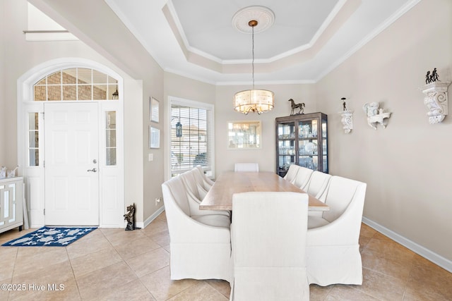 dining area with light tile patterned floors, a notable chandelier, baseboards, ornamental molding, and a tray ceiling