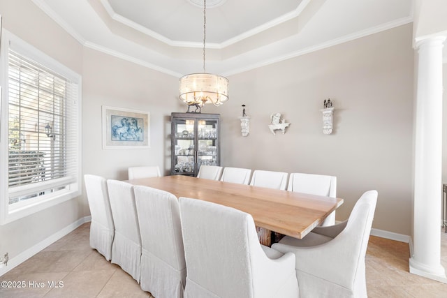 dining space with a tray ceiling, light tile patterned flooring, and decorative columns