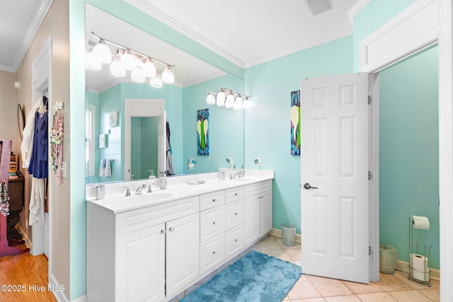 bathroom with double vanity, a sink, visible vents, and crown molding