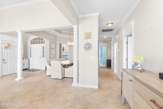 foyer entrance with crown molding, baseboards, visible vents, and ornate columns