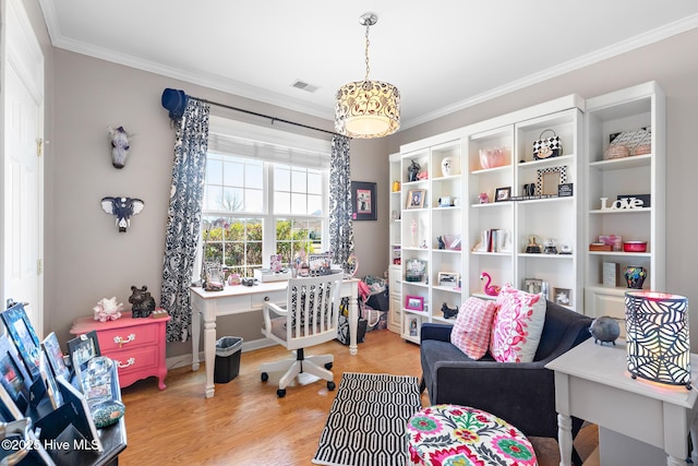 office featuring light wood finished floors, visible vents, and crown molding