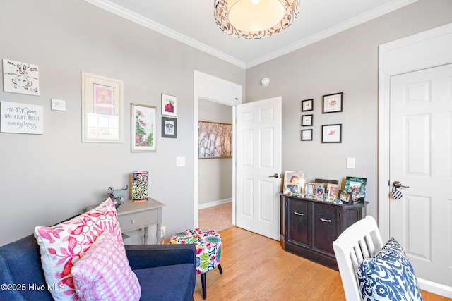 sitting room featuring light wood-type flooring, baseboards, and ornamental molding