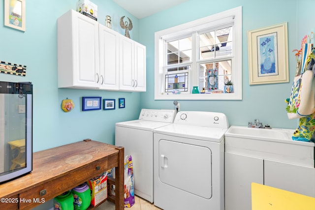 washroom featuring cabinet space, a sink, and washing machine and clothes dryer