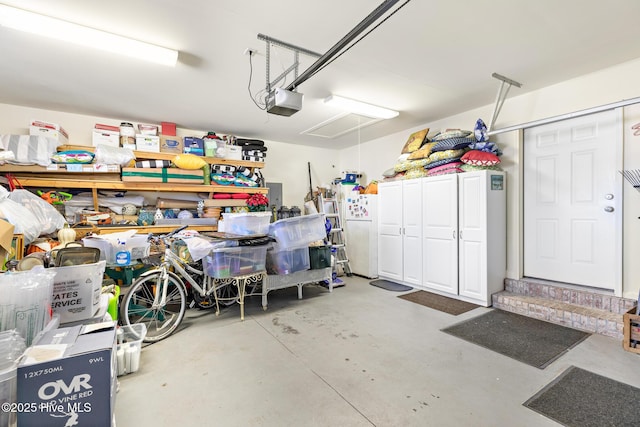 garage with a garage door opener and freestanding refrigerator