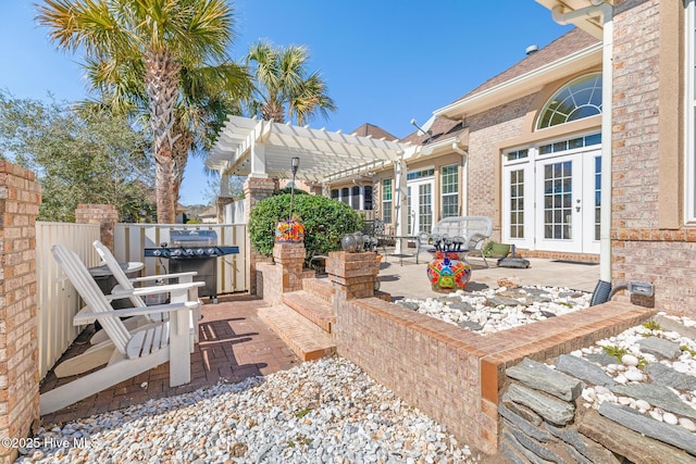 view of patio with french doors, fence, and a pergola