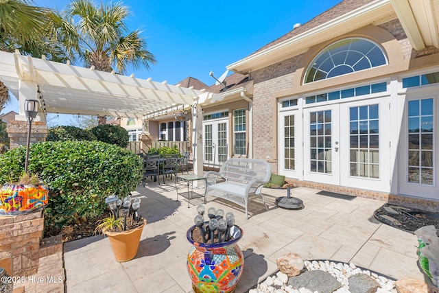 view of patio with french doors, outdoor dining area, and a pergola