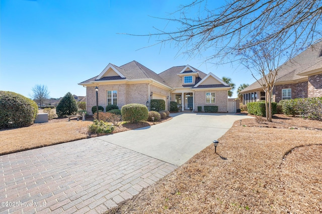 view of front facade featuring driveway, an attached garage, and brick siding