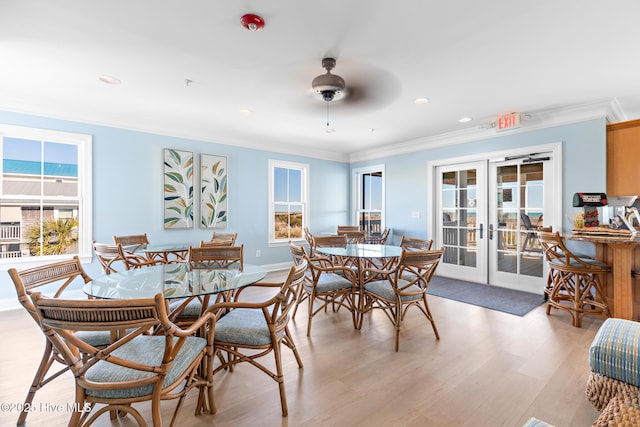 dining room featuring a ceiling fan, baseboards, ornamental molding, french doors, and light wood-type flooring