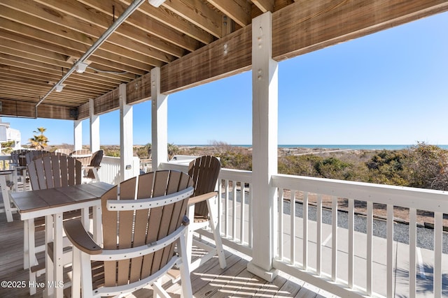 wooden deck featuring a water view and outdoor dining area