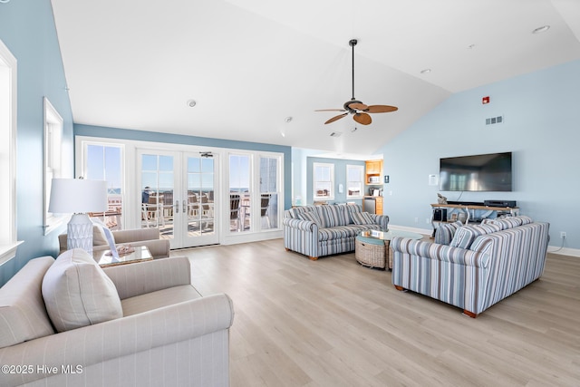 living area featuring visible vents, baseboards, lofted ceiling, french doors, and light wood-type flooring